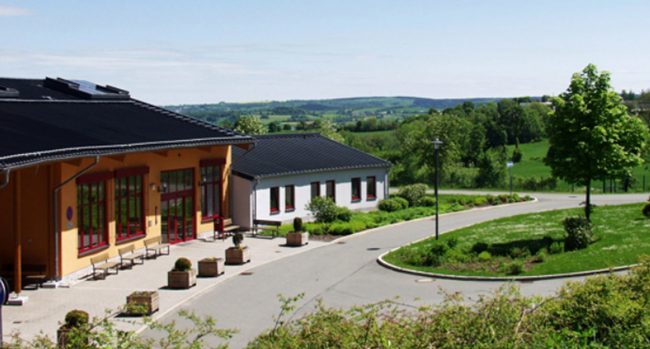 Gebäude der Lebenshilfe Annaberg in ländlicher Umgebung mit Blick auf die hügelige Landschaft im Hintergrund. Die Lebenshilfe Annaberg nutzt sowisFIBU & Co. zur Verwaltung.