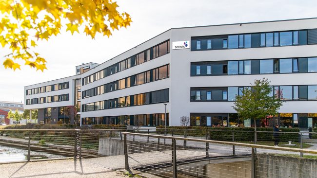 Moderne Außenansicht des Bürogebäudes der sowis GmbH mit herbstlicher Stimmung. Die sowis GmbH ist Teil der tegos Holding und entwickelt digitale Lösungen für die Sozialwirtschaft.