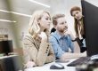 Drei Personen im Büro schauen gemeinsam konzentriert auf einen Computerbildschirm.